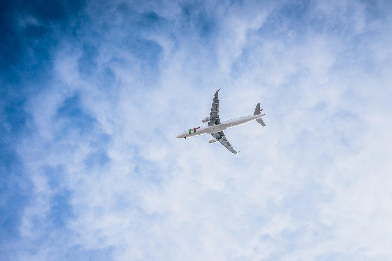 flight and hotel hacks savings - airplane above clouds
