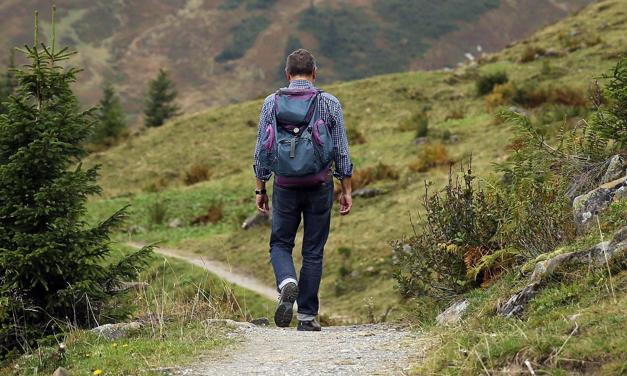 Solo traveler with backpack walking a mountain path