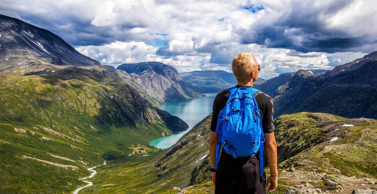 Traveler overlooking scenic mountain viewpoint while seeking hidden travel gems